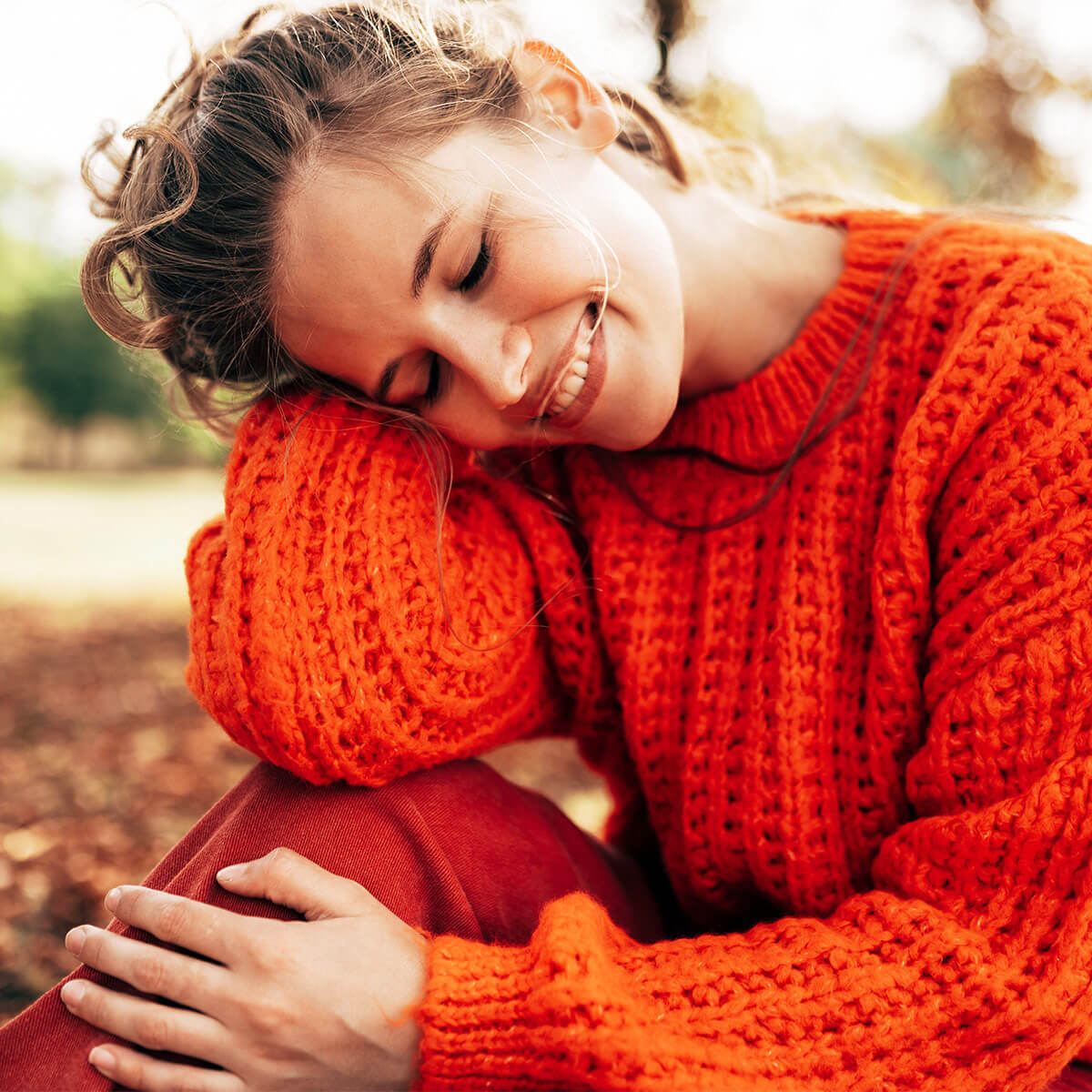 GRAPEFRUIT-KERN-EXTRAKT + Vitamin C 1200 BIO - 100 ml:  Lächelnde Frau sitzt auf einer Wiese