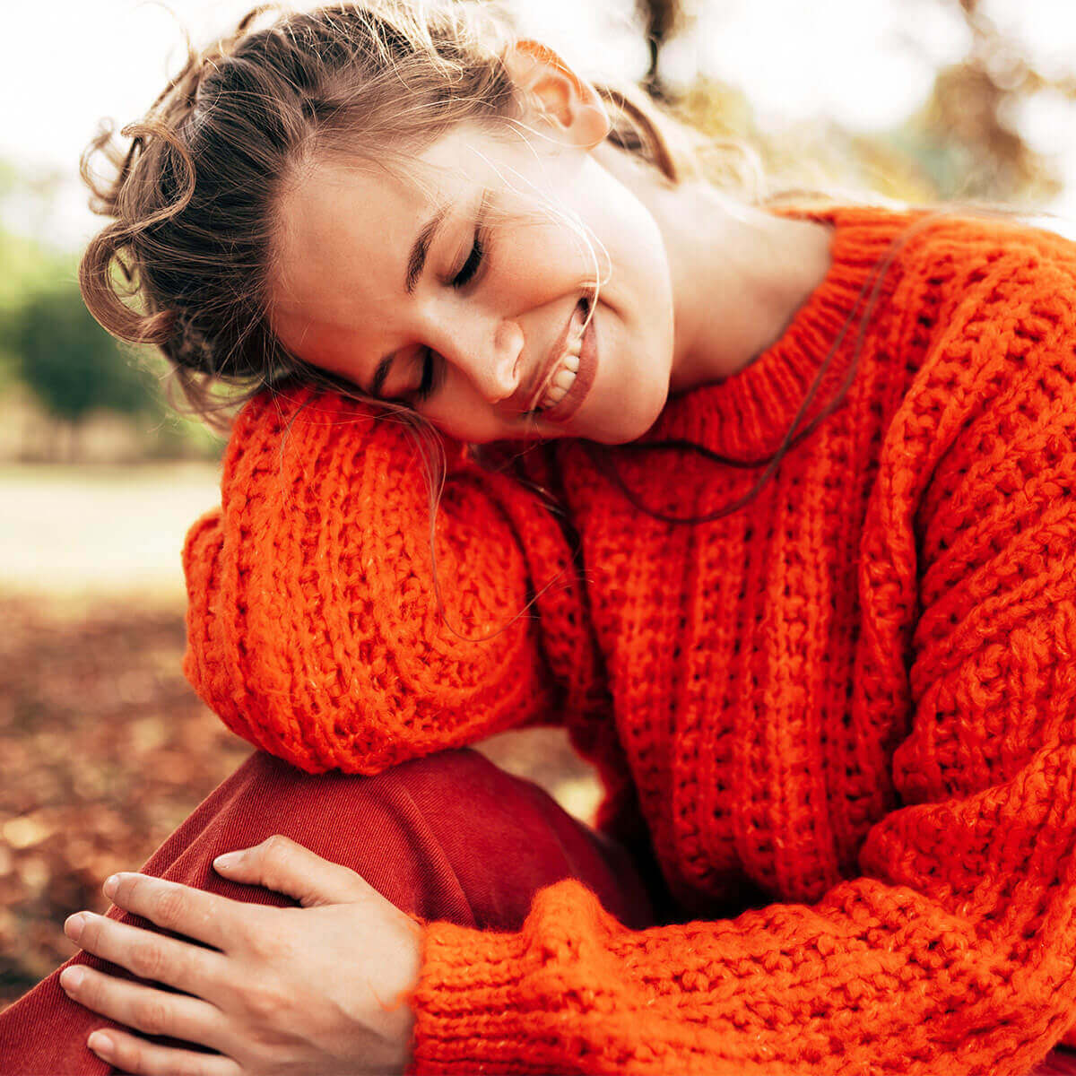 GRAPEFRUIT-KERN-EXTRAKT Tabletten + Vitamin C BIO:  Lächelnde Frau sitzt auf einer Wiese 