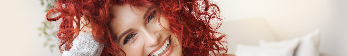 Menü-Teaser: Haare - Lächelnde Frau mit roten Haaren